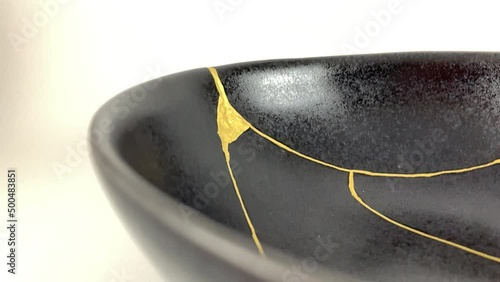 The making of kintsugi, artisan making kintsugi process. Slow motion cinematic video. Black Kintsukuroi bowl.
Closeup isolated.