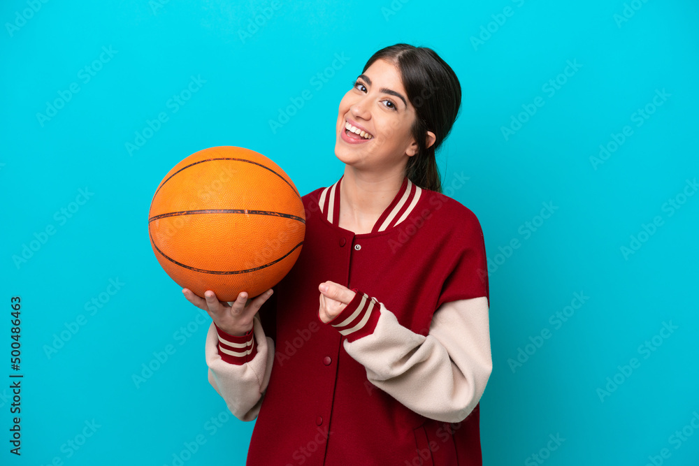 Young caucasian basketball player woman isolated on blue background celebrating a victory