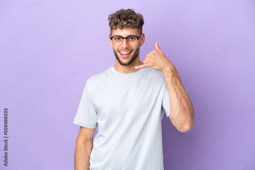 Delivery caucasian man isolated on purple background making phone gesture. Call me back sign Delivery caucasian man isolated on purple background making phone gesture. Call me back sign