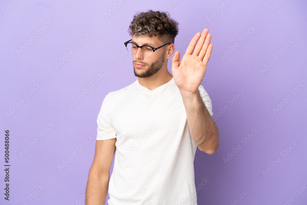 Delivery caucasian man isolated on purple background making stop gesture and disappointed Delivery caucasian man isolated on purple background making stop gesture and disappointed