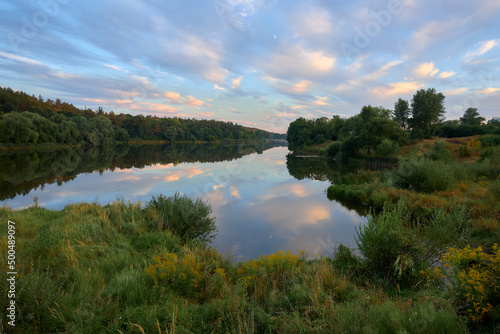 reflection of trees in water, evening on the Strizhen river in Chernihiv, Ukraine