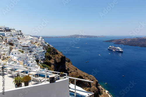 Cruise ship near Santorini island. White architecture and blue sea.