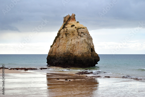 Isolated Exposed Rock on Deserted Wet Sandy Beach  