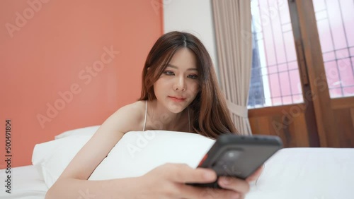 Holiday concept of 4k Resolution. Asian girls playing cell phones in the bedroom. social network. Internet communication. photo