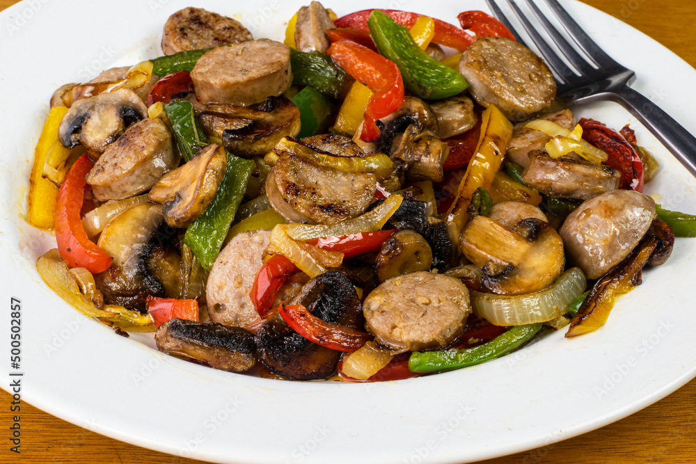 a dish of sausage onions and peppers with mushrooms a dish of sausage onions and peppers with mushrooms