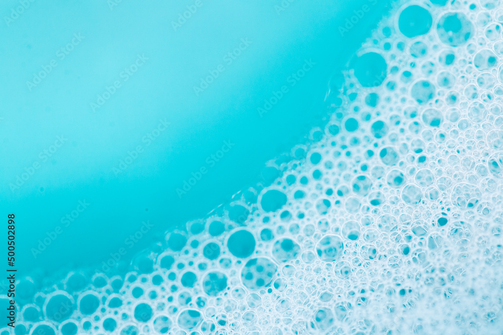 Blue water with white foam bubbles.Foam Water Soap Suds.foam bubbles. Texture Foam Close-up. blue soap bubbles background. - obrazy, fototapety, plakaty 