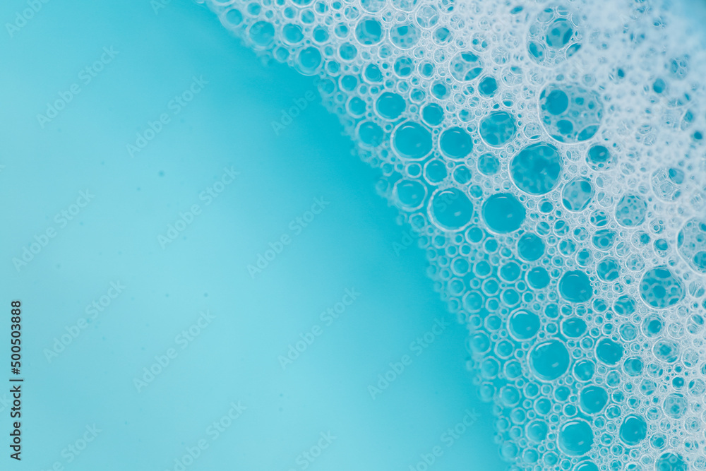 Blue water with white foam bubbles.Foam Water Soap Suds.Texture Foam Close-up. blue soap bubbles background. - obrazy, fototapety, plakaty 