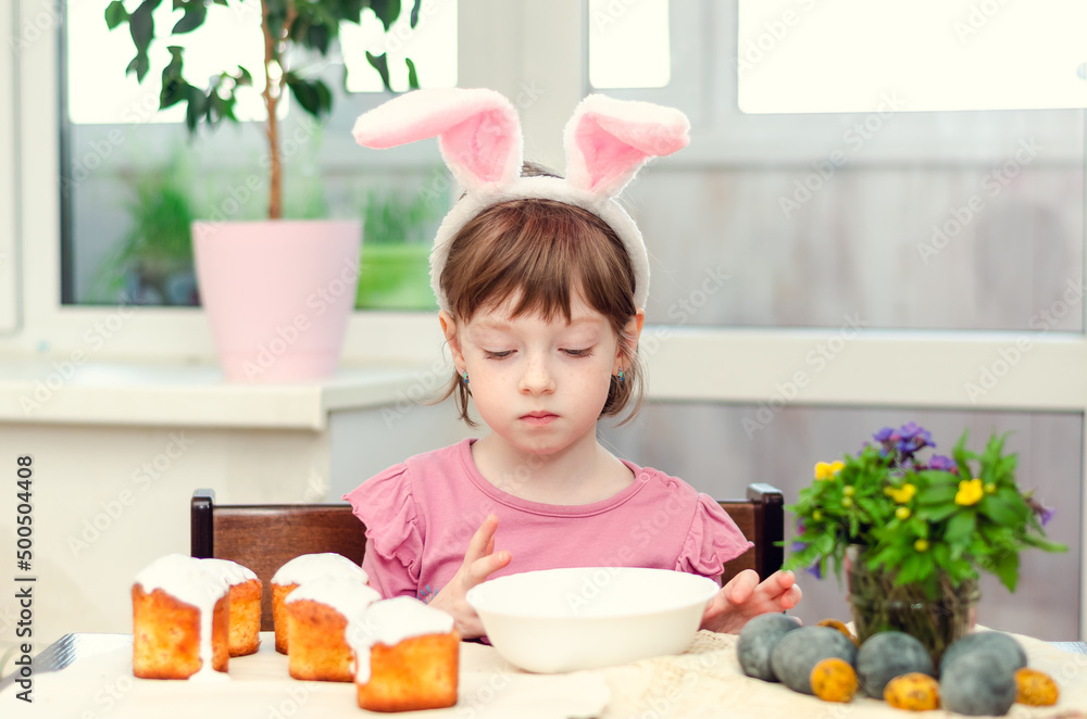 The girl decorates Easter cakes. Easter preparations. The girl decorates Easter cakes. Easter preparations.