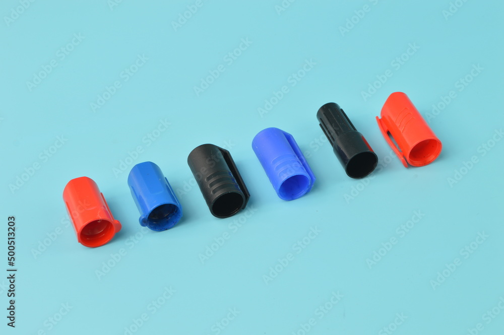 Marker pen caps in a row isolated on a blue background Marker pen caps in a row isolated on a blue background