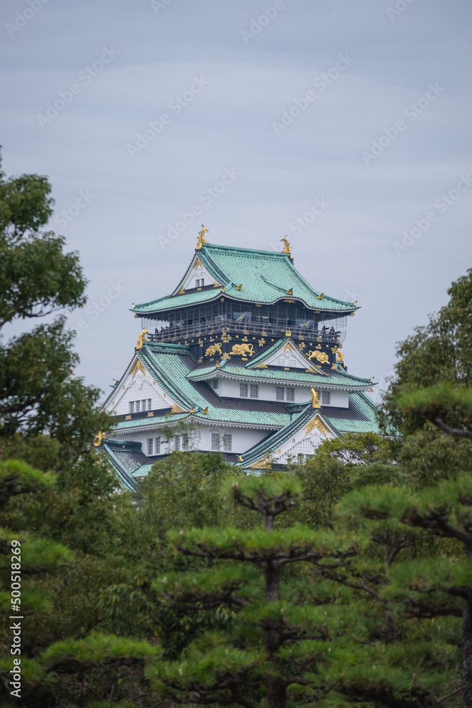 Osaka Castle framed by green trees in Osaka, Japan. Osaka Castle framed by green trees in Osaka, Japan.