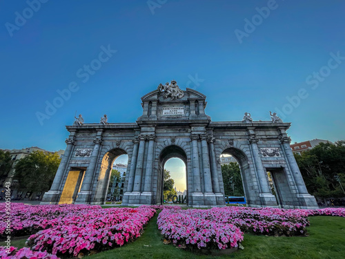 Beautiful view of the iconic (Puerta de alcala) alcala gate in spring, cover in flowers on a sunset 