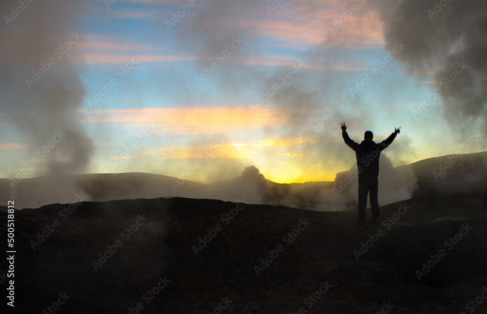 Homem de braços erquidos, abertos, no geiser, Sol de la Mañana, próximo a Uyuno, Bolivia