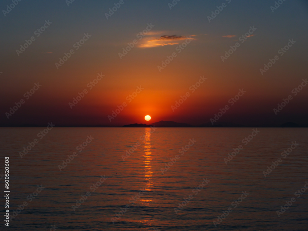 瀬戸内海の島陰に沈む夕日、横構図

