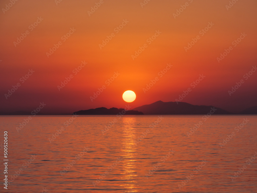 瀬戸内海の島陰に沈む夕日、横構図
