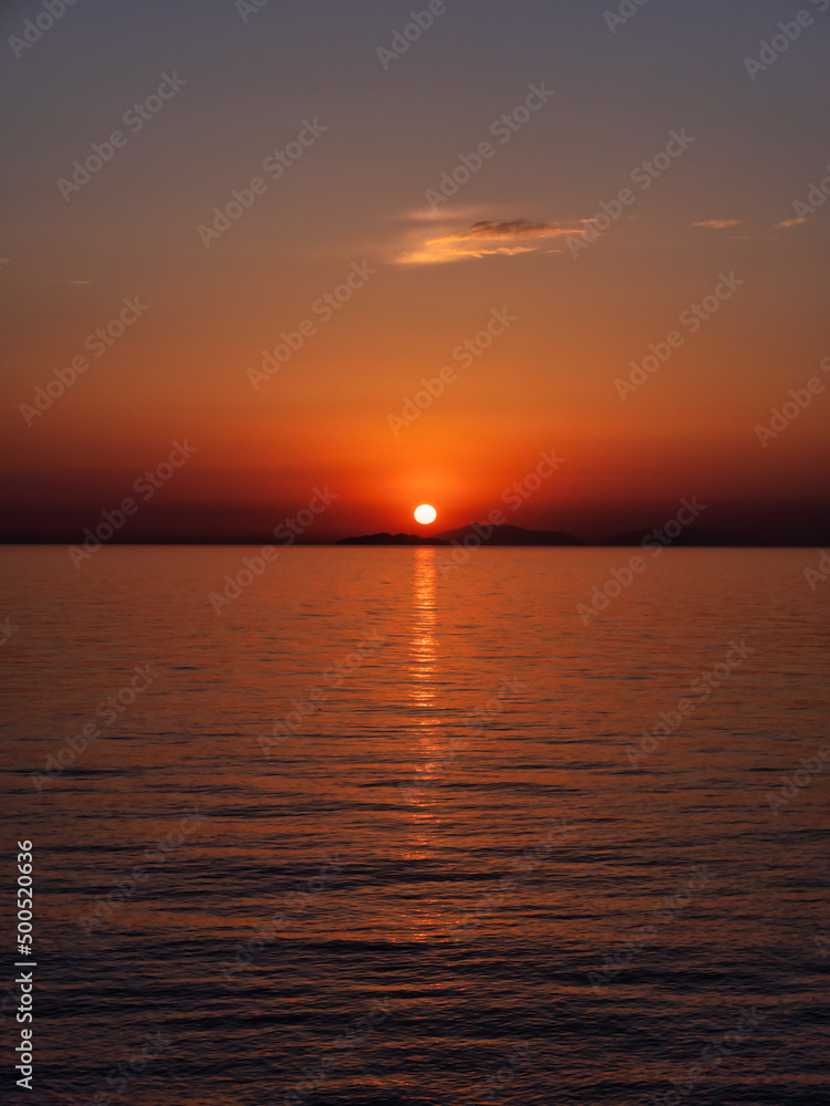 瀬戸内海の島陰に沈む夕日、縦構図
