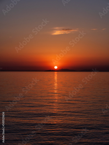 瀬戸内海の島陰に沈む夕日、縦構図 