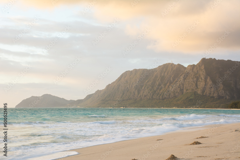 Morning sunrise at Waimanalo beach near Bellows on the windward side of Oahu in Hawaii with Koolau mountains in background.