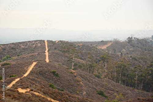Hiking a sandy trail on a hazy, smoggy day near Irvine in Orange County, California photo