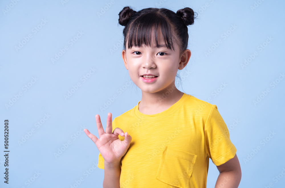 Image of Asian child posing on blue background Image of Asian child posing on blue background