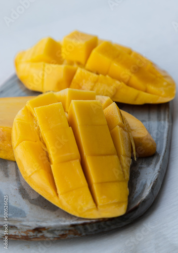 Fresh ripe yellow mango fruit (Barracuda mango) on ceramic plate. Tropical healthy fruit background, Selective focus.