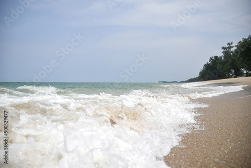 Wide angle of sea hitting the beach white sponge summer nature concept