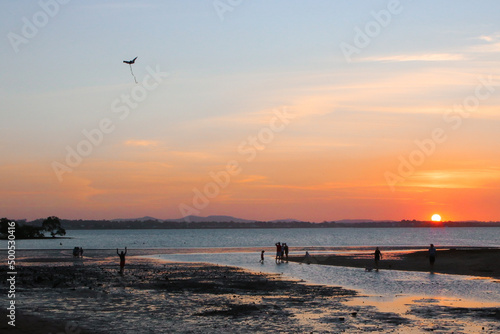 Low tide at Victoria Point. Families walking home and children playing as the sun sets