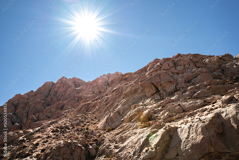 Horizontal shot of mountain valley with lens flare from sunlight