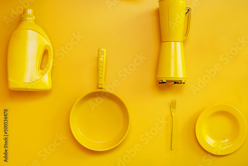 Kitchen utensils painted yellow are located on the wall. Idea for old things and objects. Decoration of living quarters with the help of various knick-knacks. flat lay frame