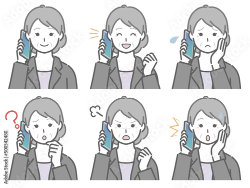 スマホで話すスーツの高齢女性