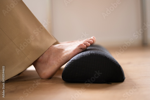 Worker Using Footrest To Reduce Back Strain