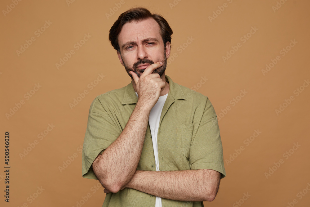 studio portrait of bearded man posing over beige background angry and thoughtfully looking into camera studio portrait of bearded man posing over beige background angry and thoughtfully looking into camera