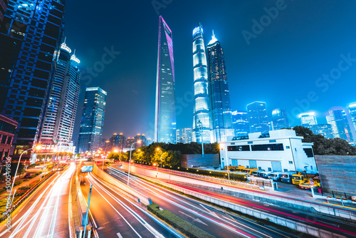 Buildings in the night view of the city and cars driving on the expressway