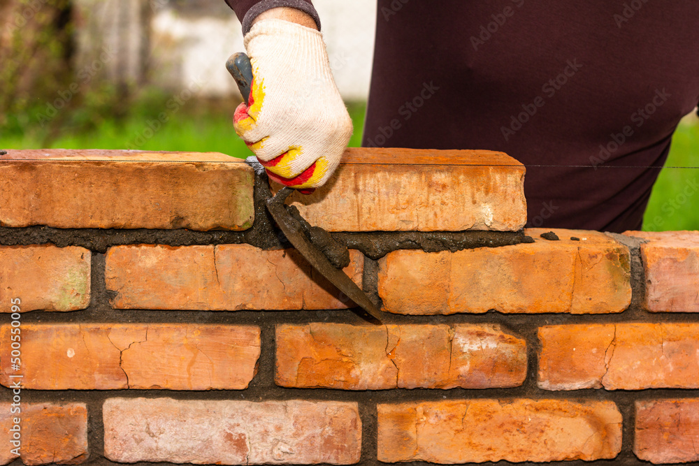 Cement or mortar, Cement mix with a trowel in a hand on the brick for  construction work. Stock Photo