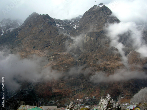 Fog engulfed the craggy terrain and coniffer pine trees after the fresh snowfall look mesmerizing at Lachung situated at 11000 ft altitude in Sikkim. Lachung is famous for its isolated natural beauty. photo