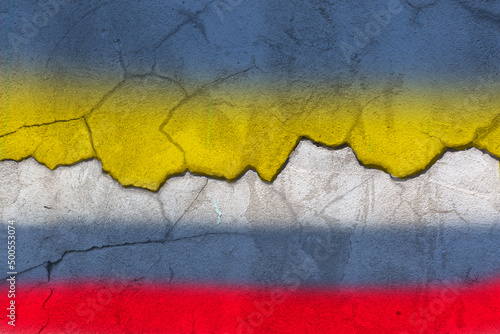 Ukraine and Russia flags on cracked texture