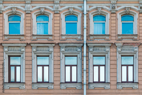 Many windows in a row on the facade of the urban historic apartment building front view, Saint Petersburg, Russia 