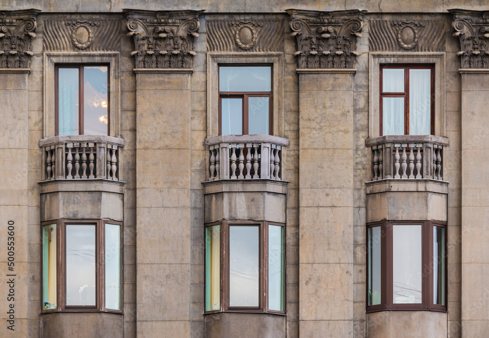 Several windows in a row on the facade of the urban historic apartment building front view, Saint Petersburg, Russia
