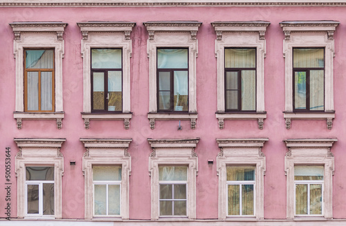 Many windows in a row on the facade of the urban historic apartment building front view, Saint Petersburg, Russia
