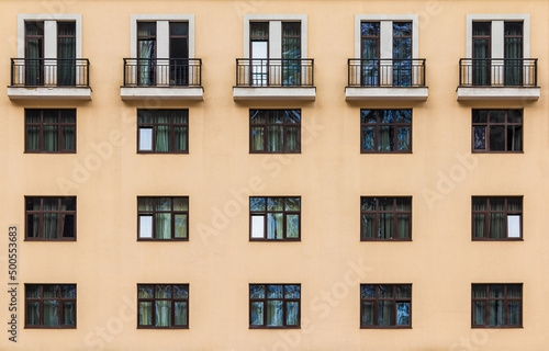 Balconies and many windows in a row on the facade of the modern urban apartment building front view, Krasnaya Polyana, Sochi, Krasnodar Krai, Russia 