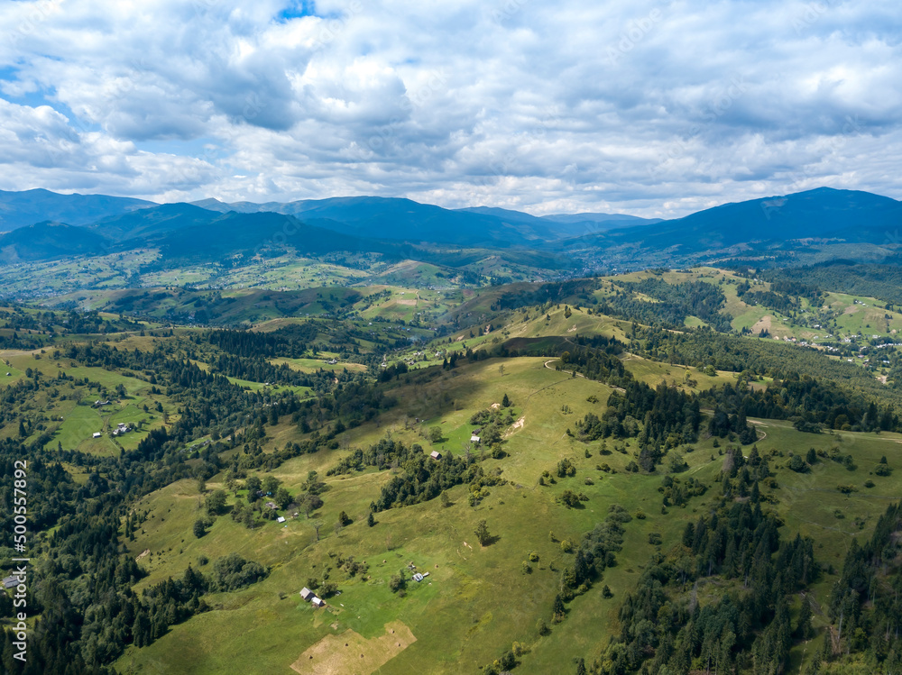 Green mountains of Ukrainian Carpathians in summer. Coniferous trees on the slopes. Aerial drone view.