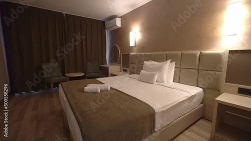 Apartments in the hotel. Excellent modern renovation in a room or hotel room. The camera moves across the entire area. Modern furniture and interior renovation. The finish is in a brown tone. photo