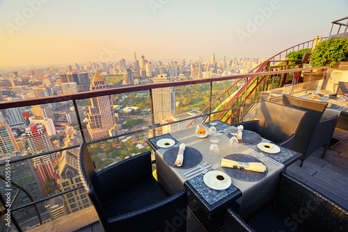 Photography Table setting on roof top restaurant with megapolis view, Bangkok Thailand