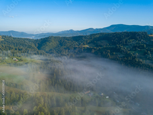 Green mountains of the Ukrainian Carpathians in the morning mist. Aerial drone view.