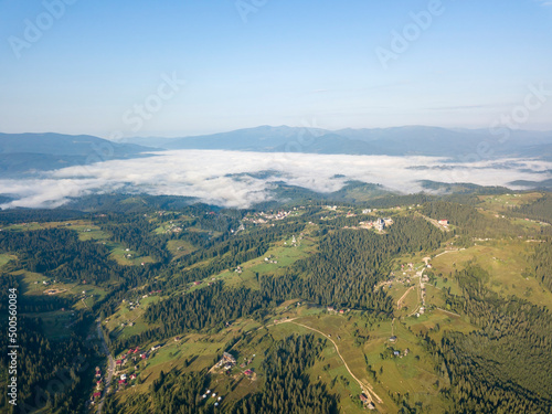 High flight in the mountains of the Ukrainian Carpathians. Fog in the valley. Aerial drone view. © Sergey