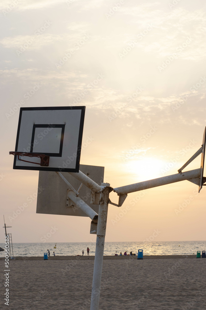 Basketball hoop at the beach in Valencia at sunrise