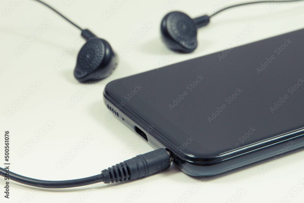Mobile phone, smartphone with headphones. Relaxation time with music. White background Mobile phone, smartphone with headphones. Relaxation time with music. White background