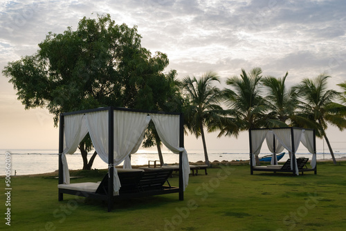 Loungers on beach at sunrise, Amaya Beach Hotel