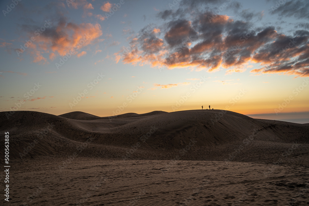 Horizontal shot of colorful sunset on the dunes of Concón and silhouettes in the background, Chile
