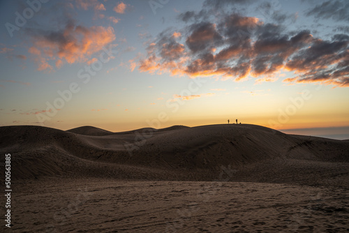 Horizontal shot of colorful sunset on the dunes of Concón and silhouettes in the background, Chile