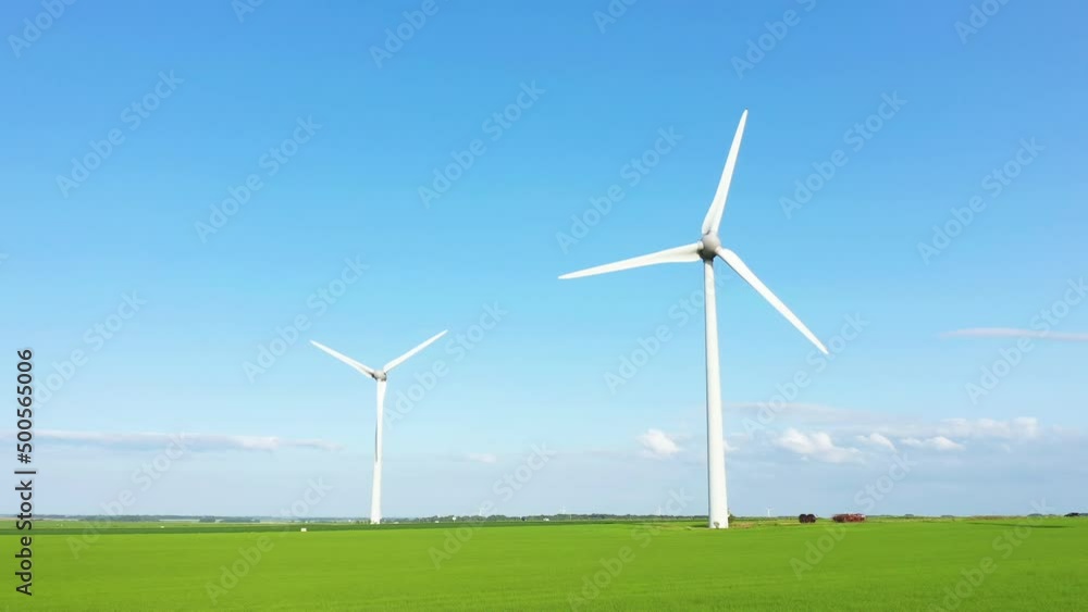 Norman wind turbines in the middle of flax and barley fields, in Europe, France, Normandy, Seine Maritime, towards Fecamp, in summer, on a sunny day. Norman wind turbines in the middle of flax and barley fields, in Europe, France, Normandy, Seine Maritime, towards Fecamp, in summer, on a sunny day.